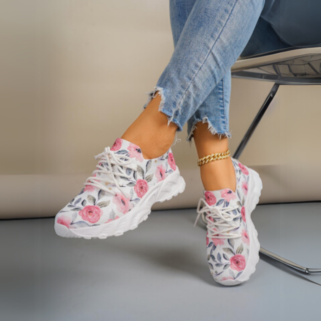 Damen-Sneaker mit Blumenmuster, weiße Sohle, kombiniert mit zerrissenen Jeans. Modische Freizeitschuhe, ideal für Frühling und Sommer.