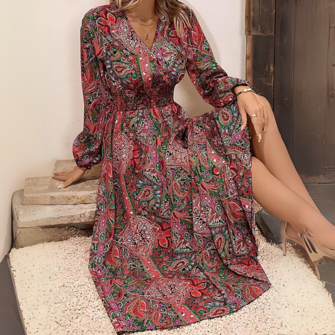Frau in langem, rotem Paisley-Kleid sitzt auf Treppe. Elegantes Design, modisches Muster, Herbstmode, stilvolle Damenbekleidung.