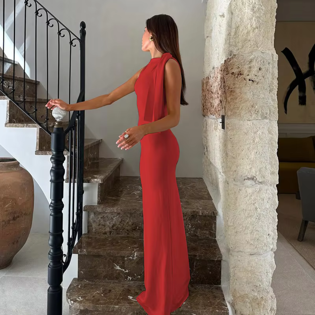 Frau in elegantem roten Abendkleid auf Marmortreppe, stilvolle Inneneinrichtung, luxuriöses Ambiente, Mode, Abendgarderobe, modernes Design.