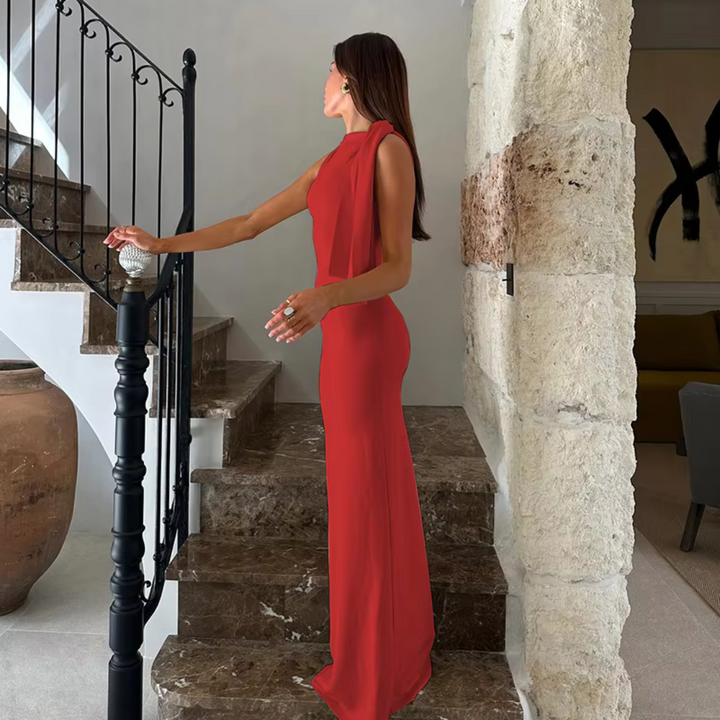Frau in elegantem roten Abendkleid auf Marmortreppe, stilvolle Inneneinrichtung, luxuriöses Ambiente, Mode, Abendgarderobe, modernes Design.