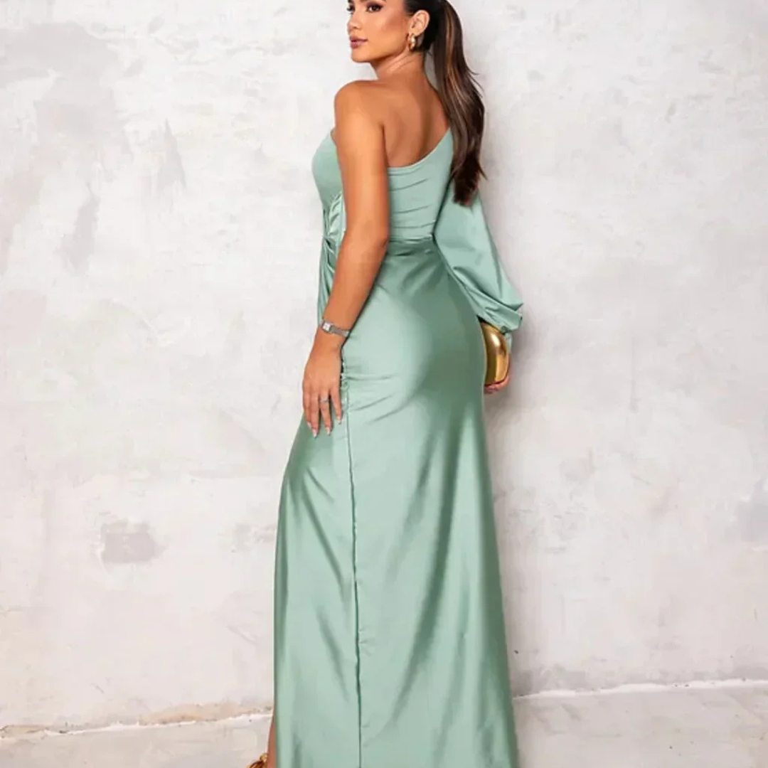 Eine Frau in einem eleganten, schulterfreien, mintgrünen Abendkleid posiert vor einer neutralen Wand. Perfekt für Mode- und Abendkleid-Suchanfragen.