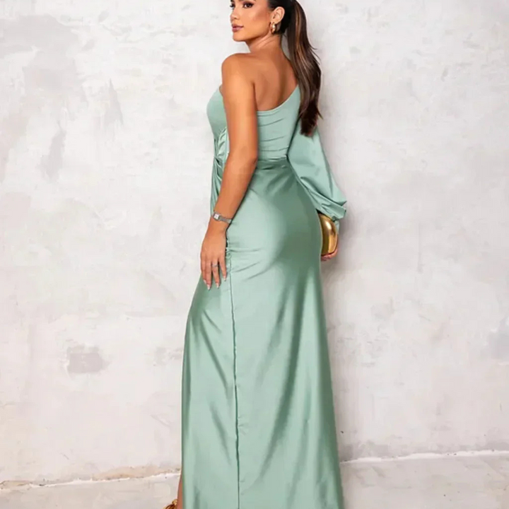 Eine Frau in einem eleganten, schulterfreien, mintgrünen Abendkleid posiert vor einer neutralen Wand. Perfekt für Mode- und Abendkleid-Suchanfragen.