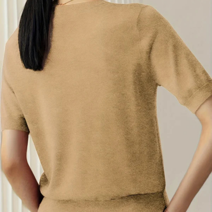 Rückansicht einer Frau in einem beigefarbenen T-Shirt, glattes schwarzes Haar, moderne Mode, minimalistisch, neutraler Hintergrund.