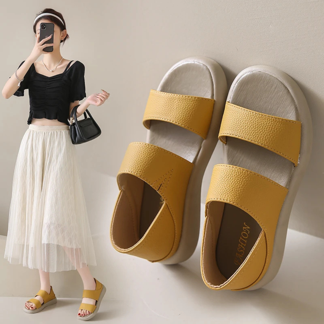 Gelbe Sandalen mit zwei Riemen, kombiniert mit modischer Frau in schwarzem Top und weißem Rock. Sommermode, bequeme Schuhe, trendiger Look.