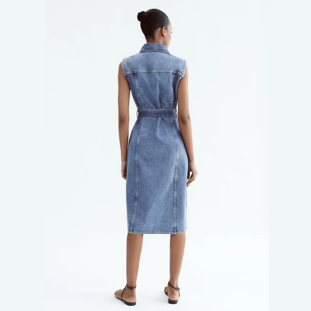 Frau in ärmellosem Jeanskleid, Rückansicht. Modisches Denim-Kleid, knielang, mit Gürtel. Sommermode, lässiger Stil, Damenbekleidung.