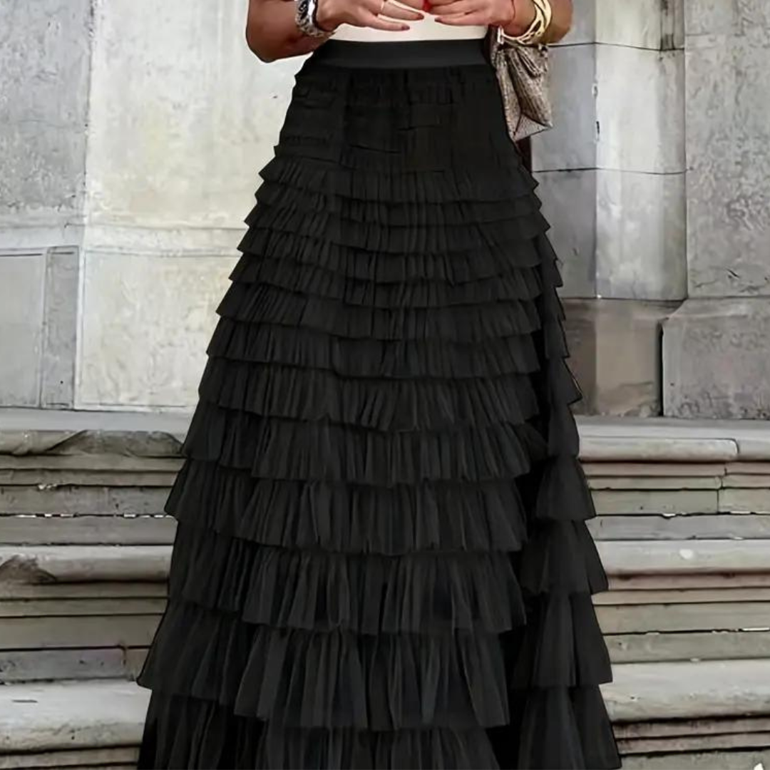 Elegantes schwarzes Stufenrock-Kleid vor steinernen Treppen, modisches Abendoutfit, ideal für formelle Anlässe und stilvolle Events.