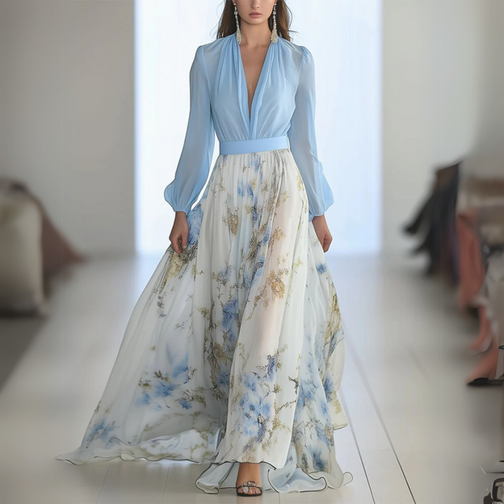 Frau in elegantem, langem, blau-weißem Kleid mit Blumenmuster auf Laufsteg. Modenschau, stilvolle Abendmode, fließender Stoff.