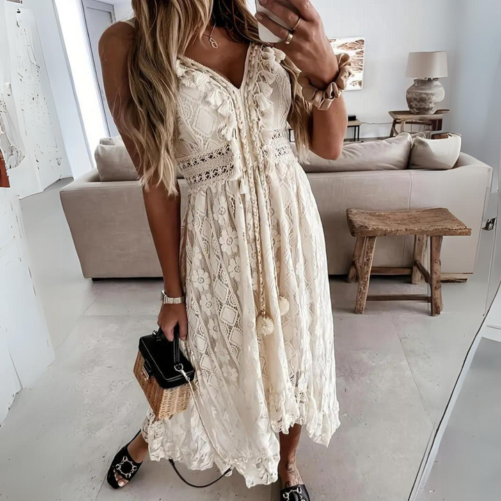 Frau in weißem Spitzenkleid macht Selfie im Wohnzimmer, hält kleine Handtasche. Sommermode, Boho-Stil, elegantes Outfit, Innenraumdekor.