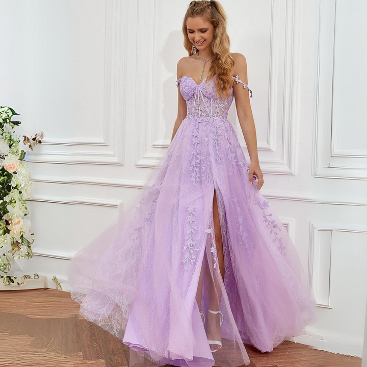 Lila Abendkleid mit Spitzenapplikationen, herzförmigem Ausschnitt und hohem Schlitz, getragen von einer Frau in elegantem Interieur.