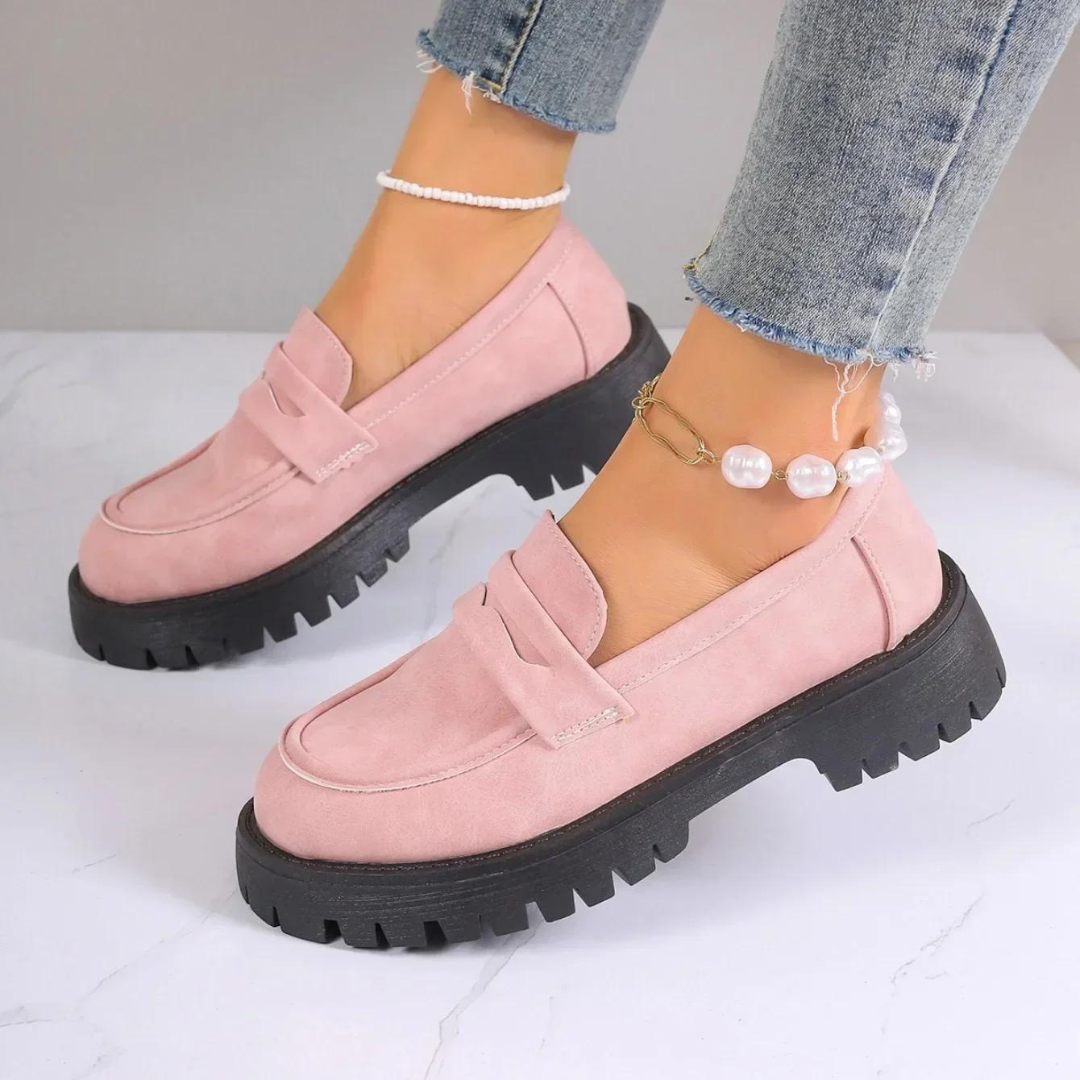 Damen rosa Loafer mit dicker schwarzer Sohle, getragen mit Jeans und Perlenknöchelketten. Modische Schuhe, trendige Damenmode, bequeme Loafer.