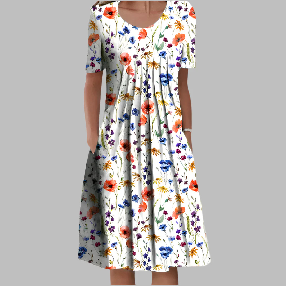 Frau in weißem Sommerkleid mit buntem Blumenmuster, kurzärmelig, knielang. Perfekt für Frühling und Sommermode. Elegantes Freizeitkleid.