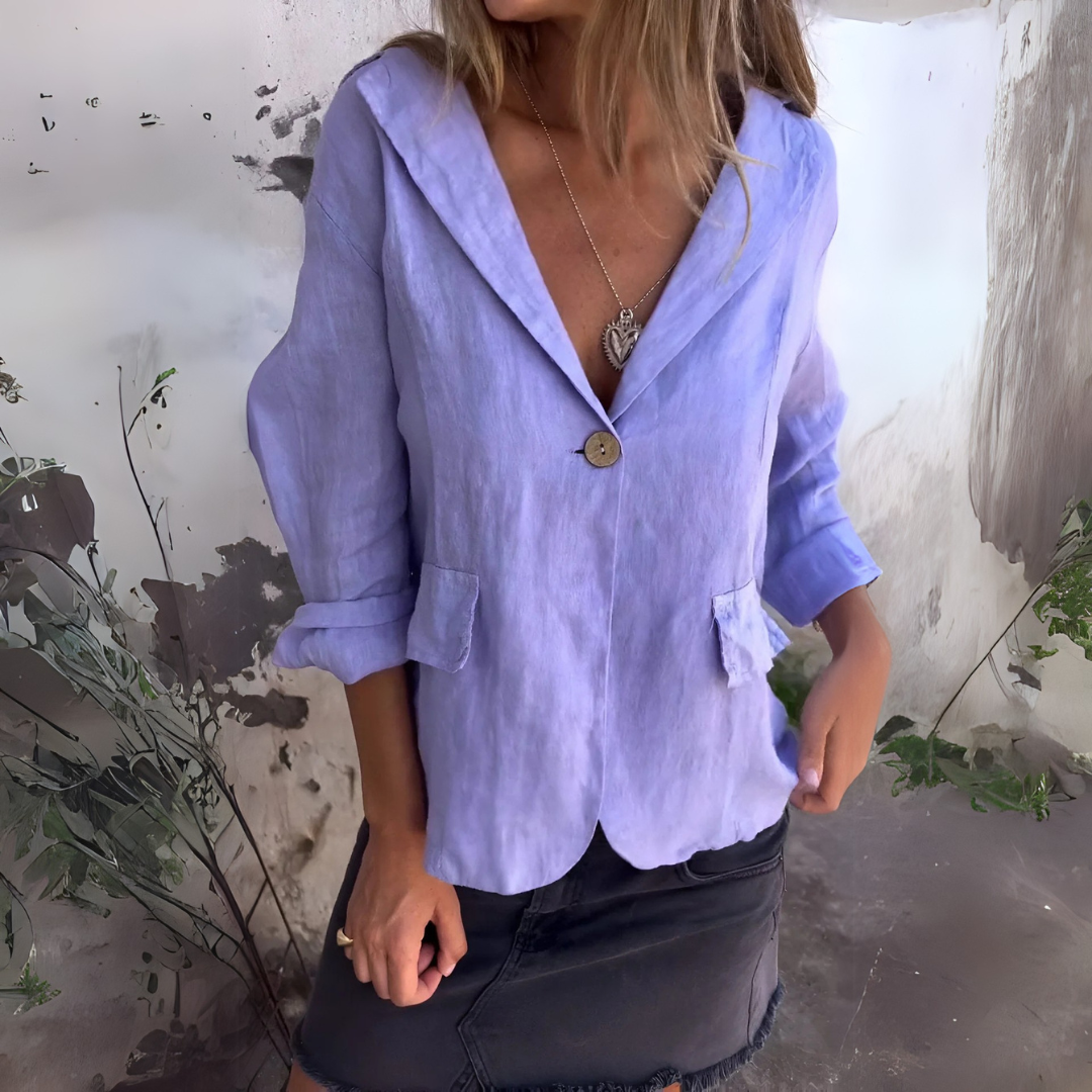 Frau in lila Leinenblazer und schwarzem Rock vor rustikalem Hintergrund. Modetrend, Damenmode, eleganter Look, Freizeitkleidung.