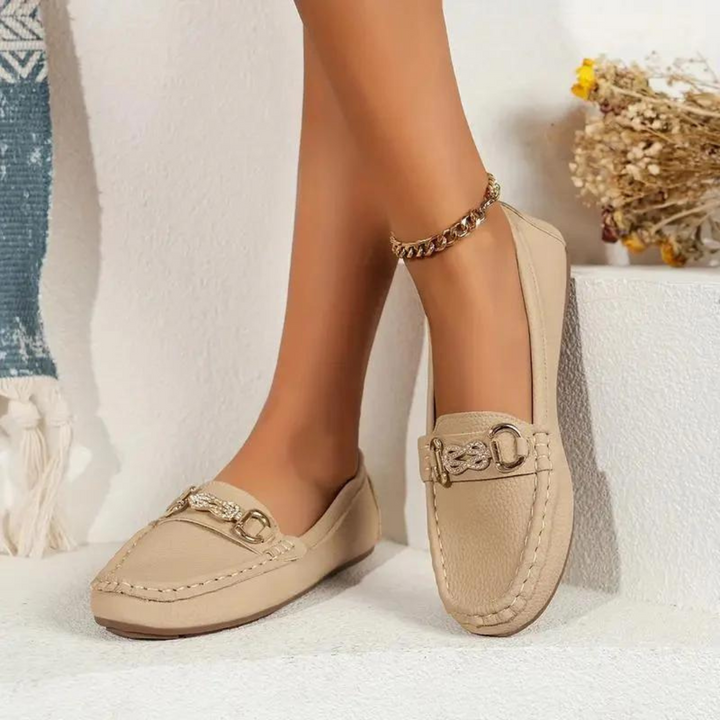Beige Damen-Loafer mit goldener Kette, elegantes Design, ideal für Frühling und Sommer, modische Freizeitschuhe auf weißem Hintergrund.