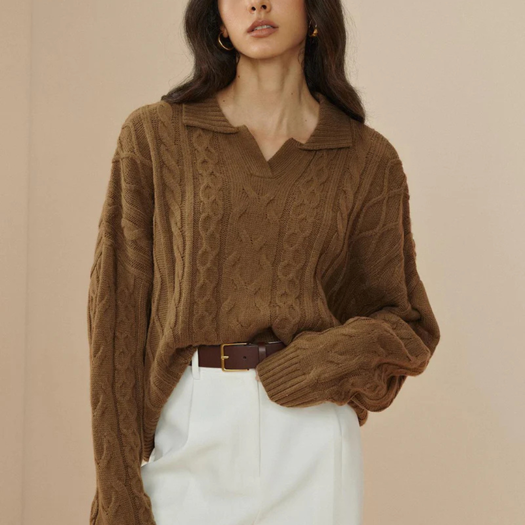 Frau in braunem Strickpullover mit Zopfmuster und weißer Hose, modischer Herbstlook, elegantes Outfit, stilvolle Damenmode, minimalistische Kleidung.