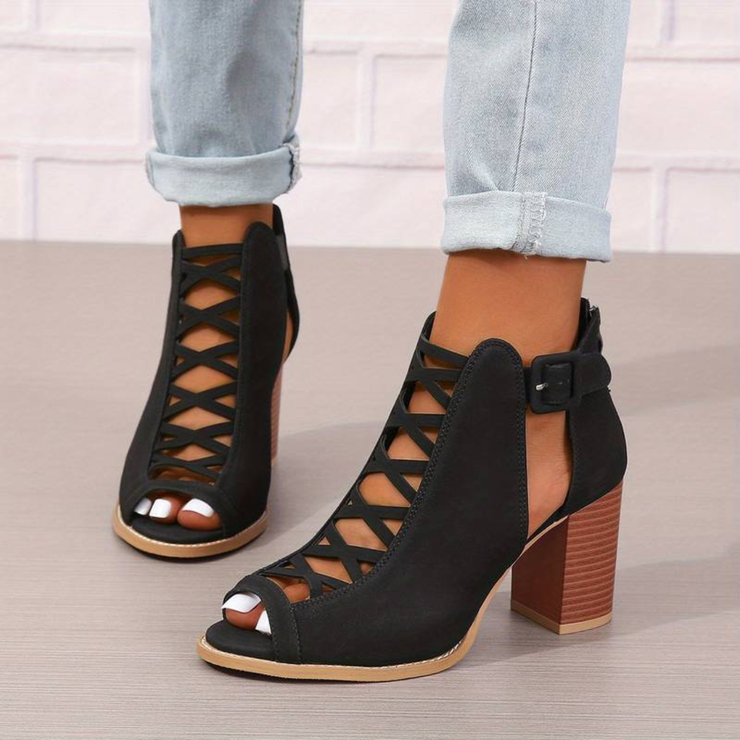 Schwarze, geschnürte Sandaletten mit Blockabsatz und offener Zehenpartie, getragen mit hochgekrempelten Jeans. Modische Damen-Sommerschuhe.