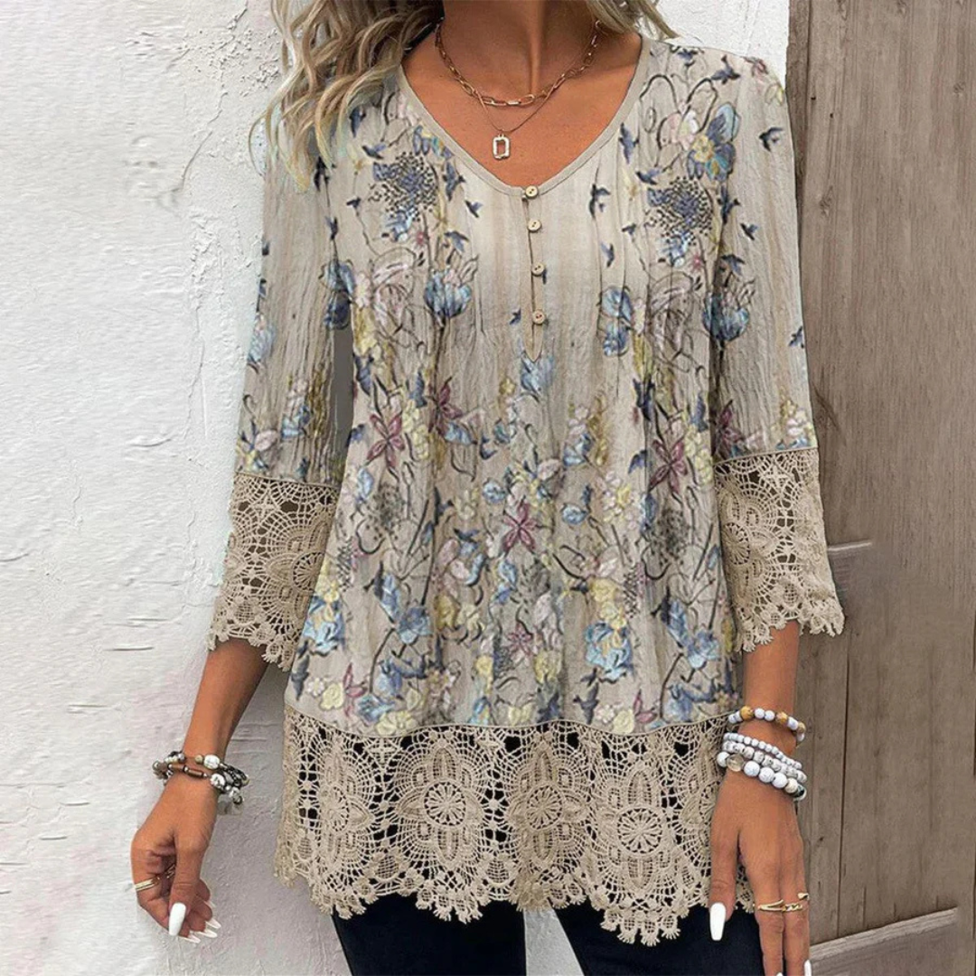 Frau trägt florale Bluse mit Spitzenärmeln, kombiniert mit Armbändern. Modetrend, Damenmode, Frühlingsoutfit, lässiger Stil.