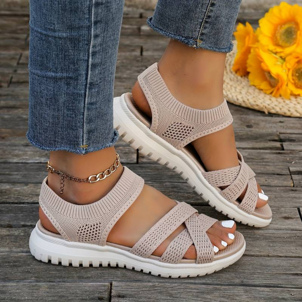 Beige Damen-Sandalen mit Strickdesign und weißer Sohle, getragen mit Jeans. Modische Sommerschuhe, ideal für Freizeit und Strand.