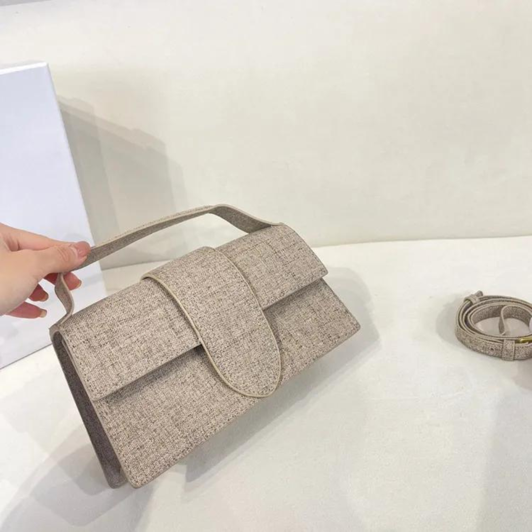 Beigefarbene Damenhandtasche aus Leinen mit Griff, minimalistisches Design, auf weißem Hintergrund. Elegante Modeaccessoires für Frauen.