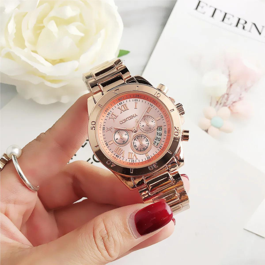 Roségoldene Damenarmbanduhr mit römischen Ziffern und Chronographen auf rosa Zifferblatt, gehalten von Hand mit rotem Nagellack, neben weißer Blume.