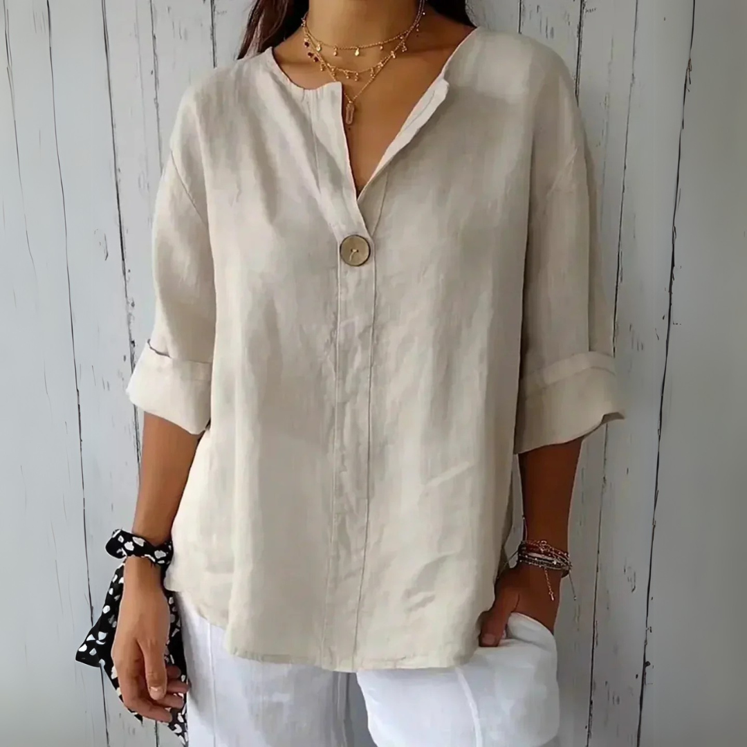 Damen Leinenbluse beige, lässig, mit Knopfdetail, 3/4-Ärmel, kombiniert mit weißer Hose. Perfekt für Sommermode und Freizeitoutfits.
