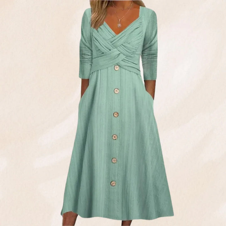 Frau in mintgrünem Kleid mit Knopfleiste und 3/4-Ärmeln, elegantes Design, Sommermode, Damenbekleidung, stilvoll und modern.