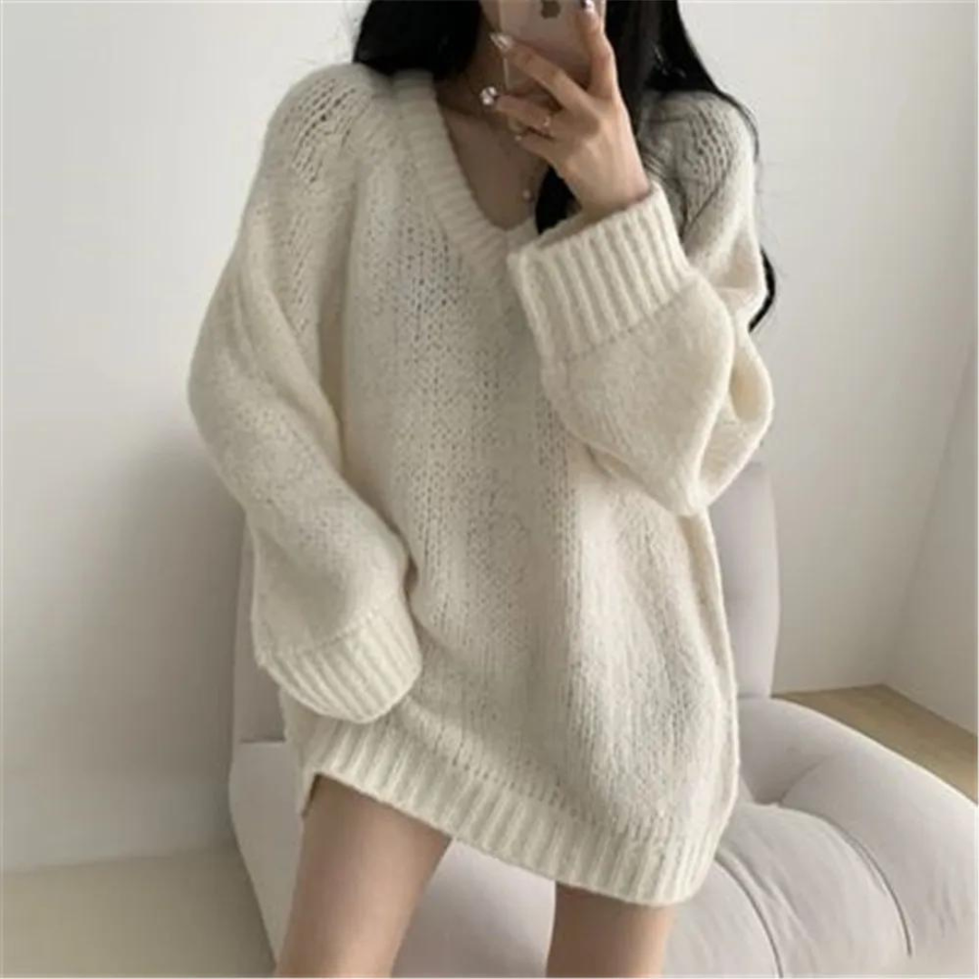 Frau in cremefarbenem Oversize-Pullover, gemütlicher Strick, modischer Herbst-Look, lässiger Stil, Selfie im Wohnzimmer.