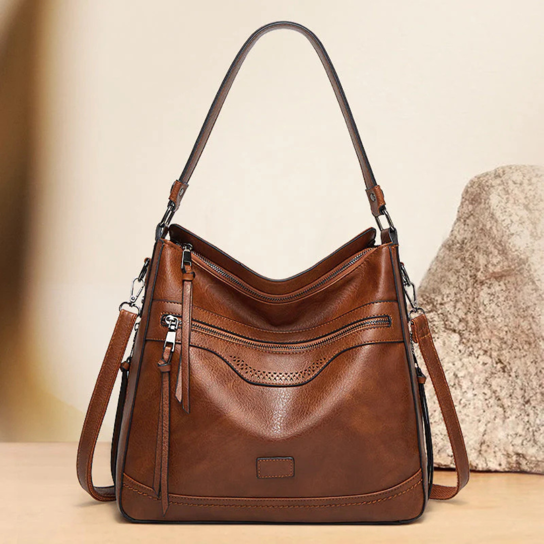 Braune Ledertasche mit Schulterriemen, elegantes Design, Reißverschlusstaschen, Damenhandtasche, modisches Accessoire, hochwertige Verarbeitung.