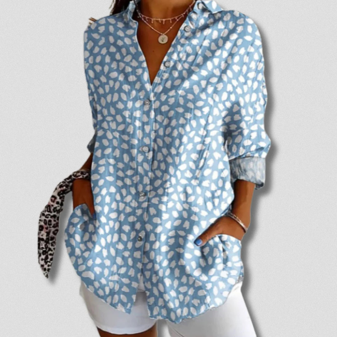Damenbluse mit blau-weißem Leopardenmuster, lässig geschnitten, kombiniert mit weißen Shorts. Modetrend, Sommeroutfit, Freizeitlook.