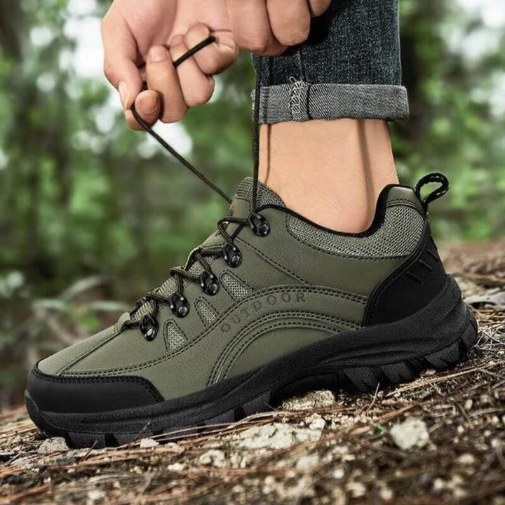 Grüner Outdoor-Wanderschuh mit robustem Profil, geschnürt auf Waldweg. Ideal für Trekking und Naturabenteuer. Hochwertige Materialien.