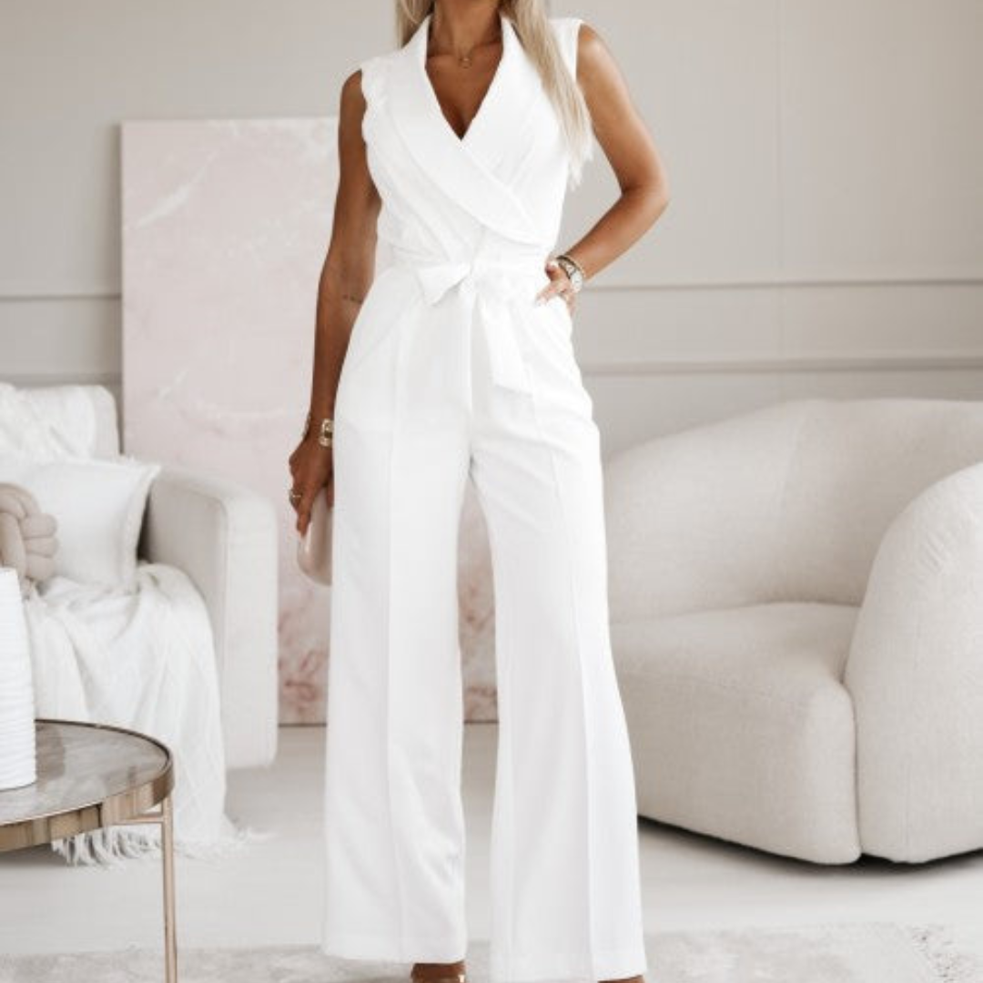 Eleganter weißer Jumpsuit für Damen, ärmellos mit Wickeldesign, ideal für Sommermode und stilvolle Anlässe, präsentiert in modernem Wohnzimmer.