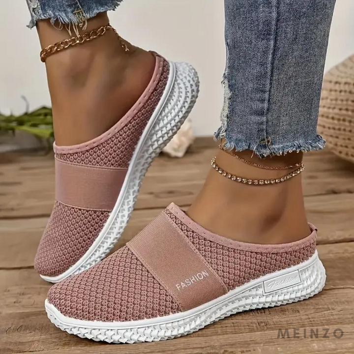 Damen Sneaker in Rosa, atmungsaktiv mit elastischem Band, weiße Sohle, getragen mit Jeans und Fußkettchen. Ideal für Freizeit und Mode.