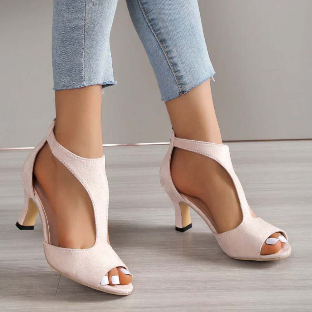 Damen High Heels Sandaletten in Beige mit Cut-Out-Design, offener Zehenpartie und Stiletto-Absatz, kombiniert mit hellblauen Jeans.