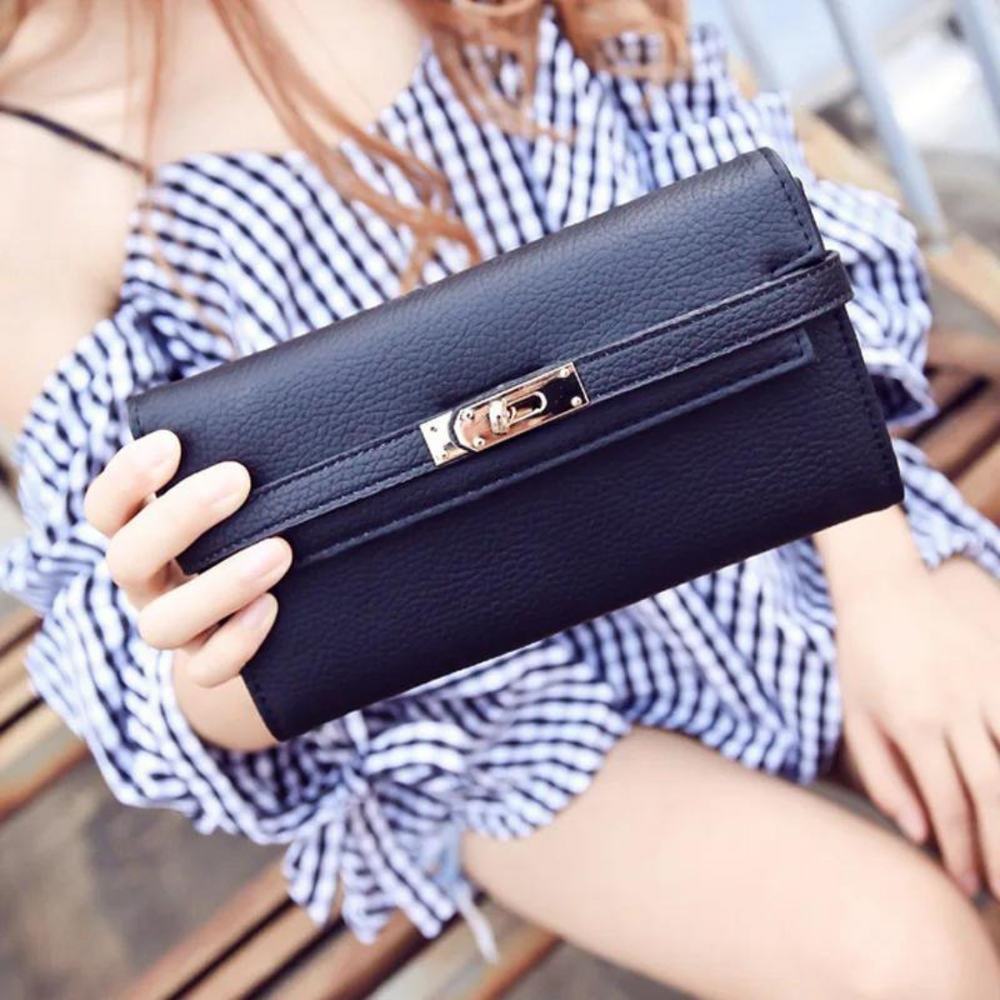Frau hält schwarze Lederhandtasche, modisches Accessoire, elegantes Design, ideal für Damenmode, stilvoller Look, perfekte Ergänzung für Outfits.