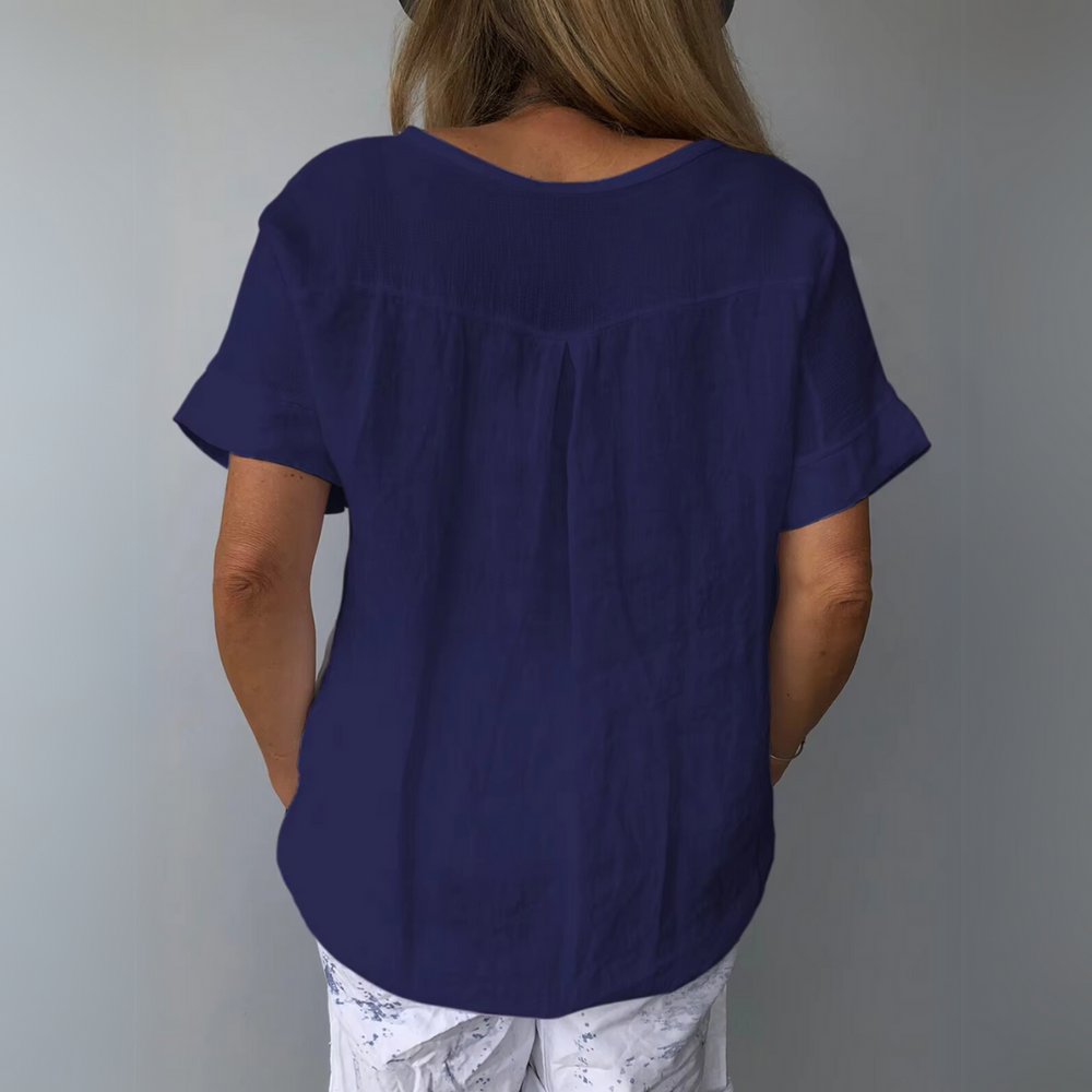 Frau in dunkelblauer Bluse und weißer Hose von hinten, lässiger Sommerlook, modische Damenbekleidung, Freizeitoutfit, stilvoll und bequem.