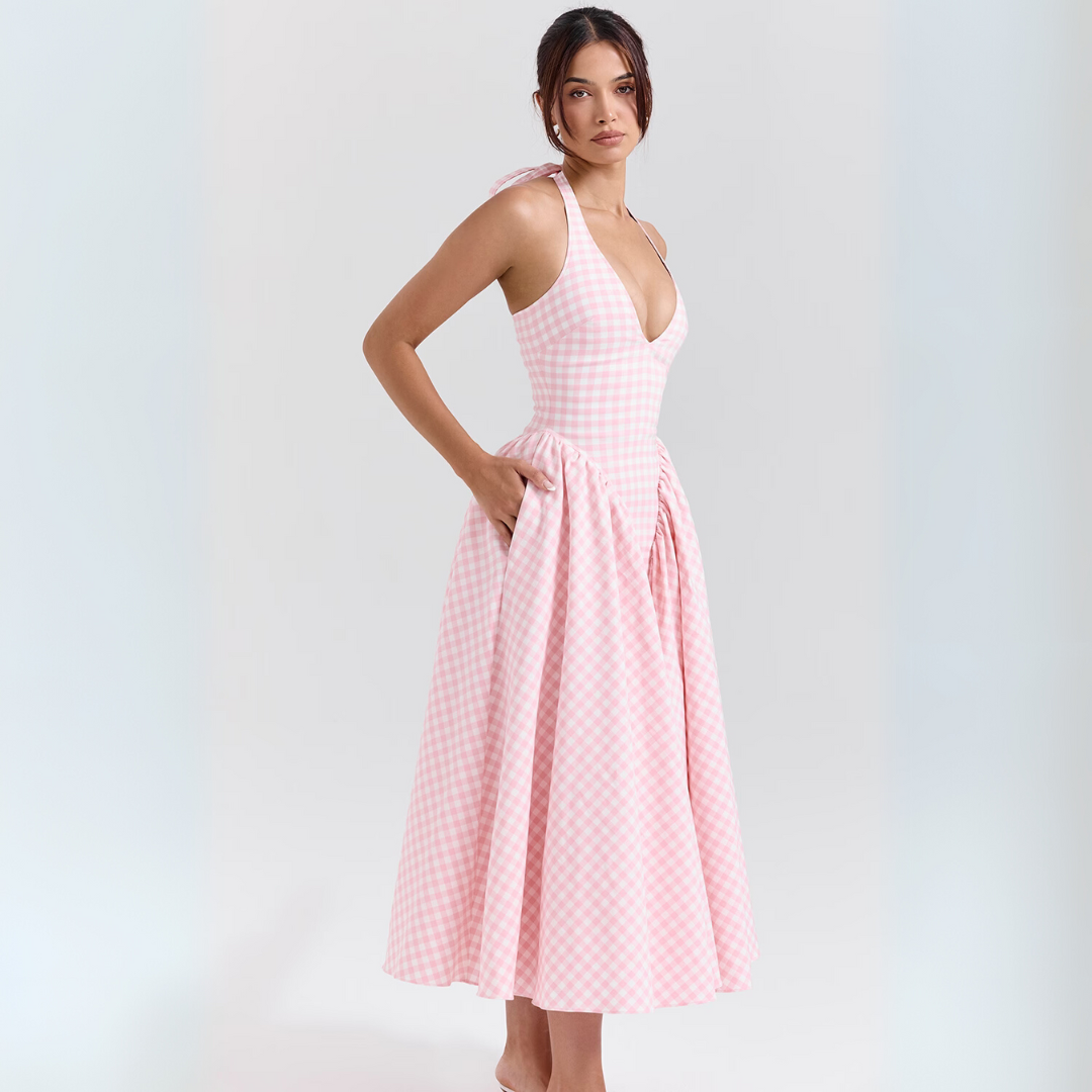 Frau in rosa-weiß kariertem Sommerkleid mit V-Ausschnitt und Taschen, ärmellos, knielang, modisch, elegant, ideal für warme Tage.