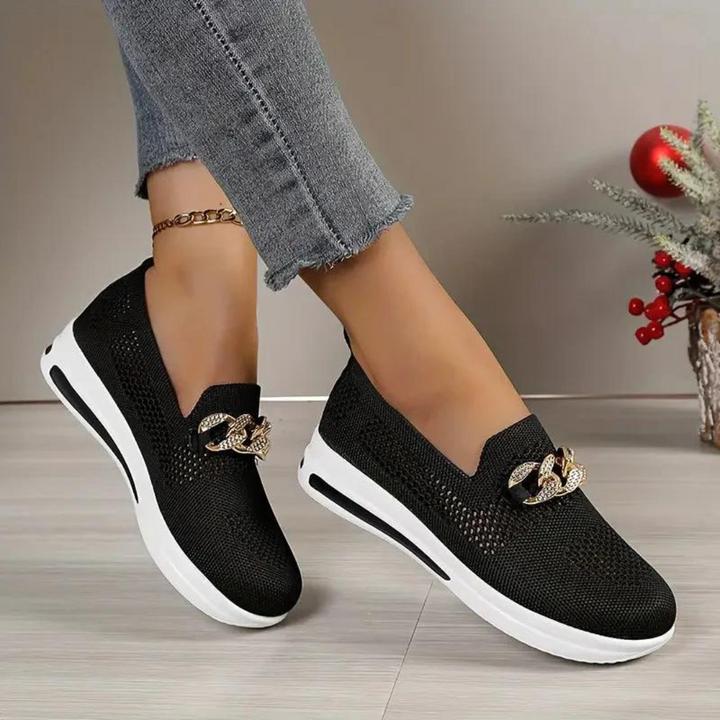 Damen Sneaker in Schwarz mit goldener Kettendekoration, weiße Sohle. Modische Freizeitschuhe, bequem und stilvoll, ideal für den Alltag.