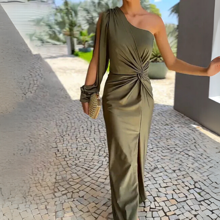 Ein elegantes, einseitiges, olivgrünes Abendkleid mit Knoten-Detail, getragen von einer Frau auf einem gepflasterten Weg. Perfekt für formelle Anlässe.