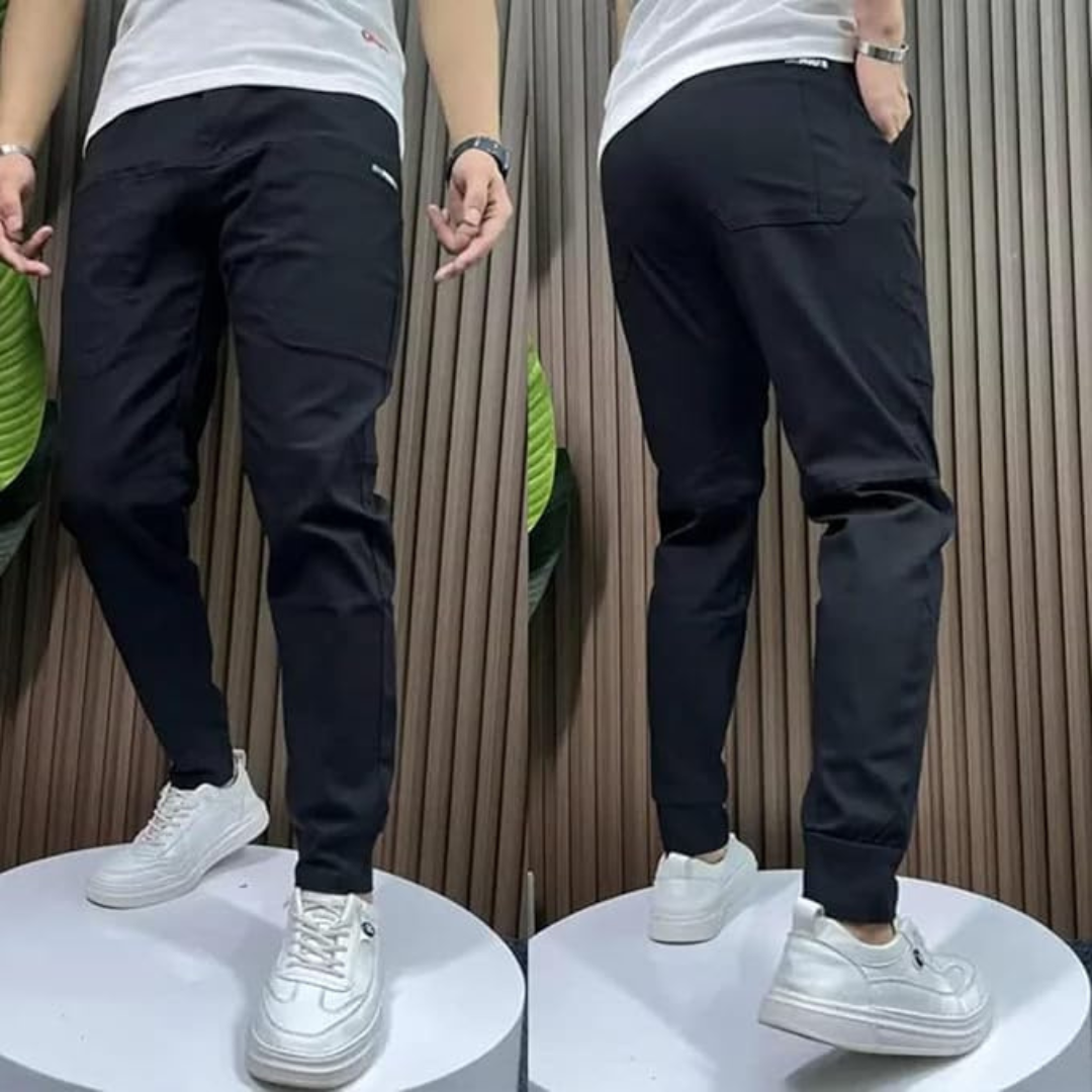 Schwarze Jogginghose für Herren, seitlich und von hinten gezeigt, kombiniert mit weißen Sneakers. Bequeme Sporthose, ideal für Freizeit und Fitness.