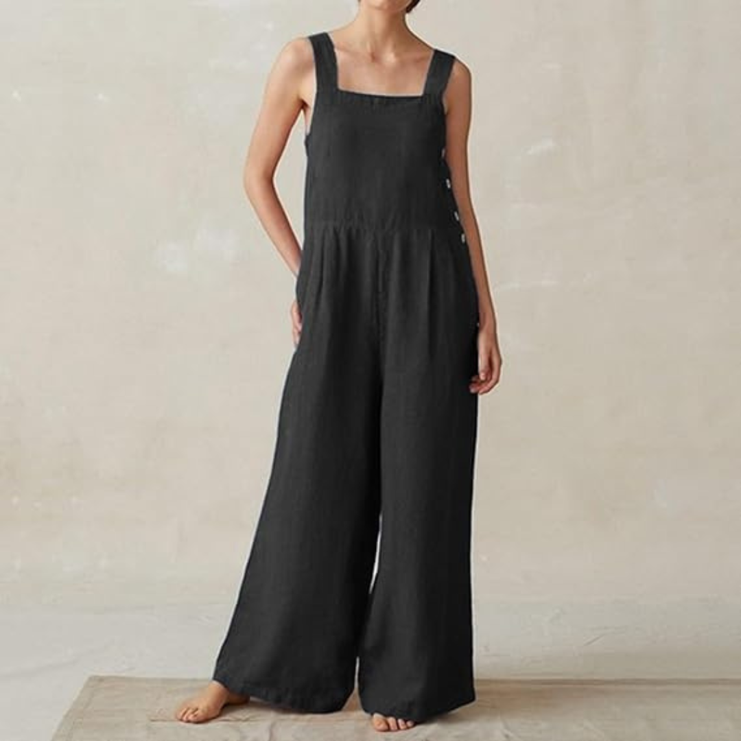 Frau in schwarzem Leinen-Jumpsuit mit weitem Bein, ärmellos, seitliche Knöpfe, minimalistischer Stil, modisch, bequem, ideal für Sommer.