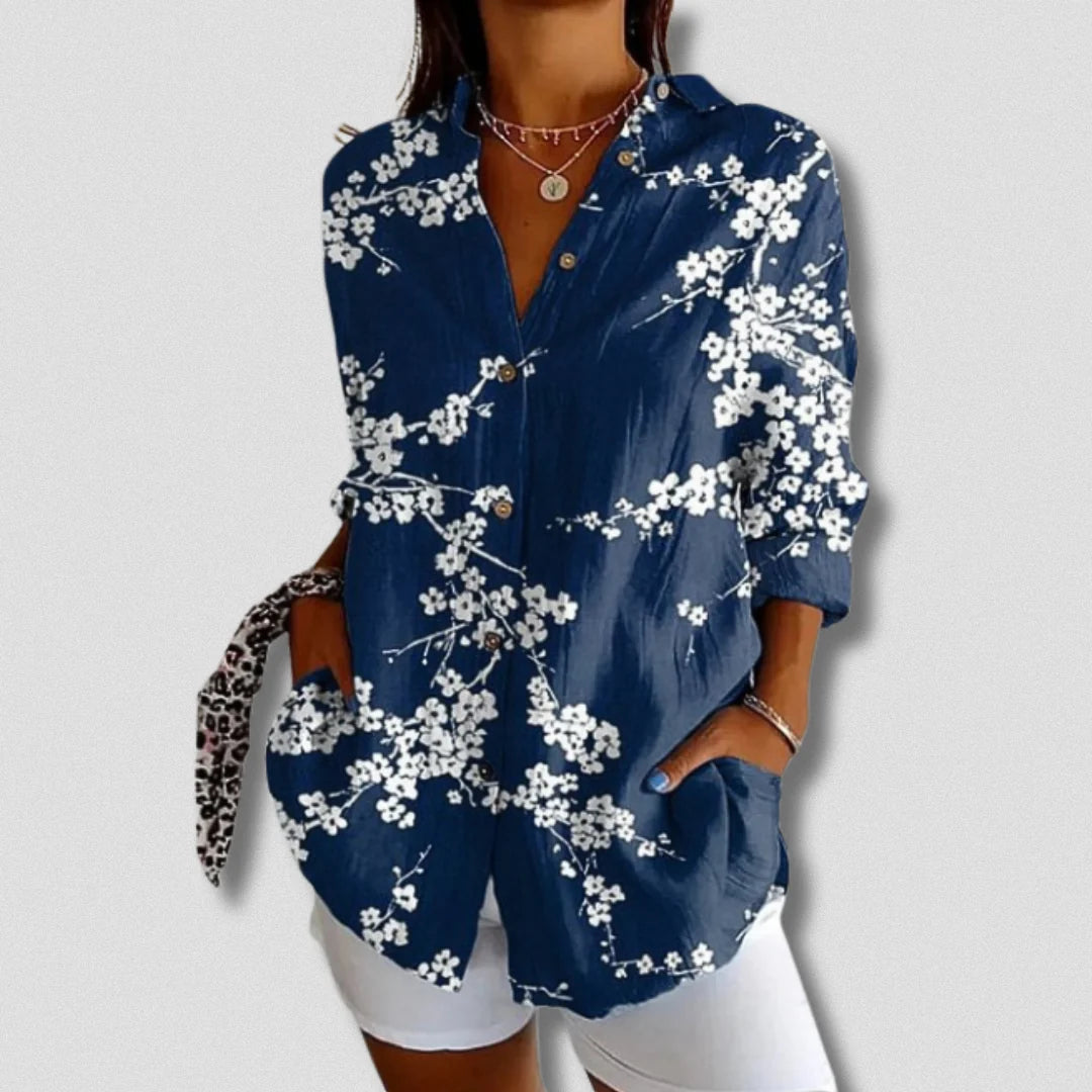Damenbluse mit blauem Hintergrund und weißem Blumenmuster, lange Ärmel, Knopfleiste, lässiger Stil, ideal für Frühling und Sommermode.