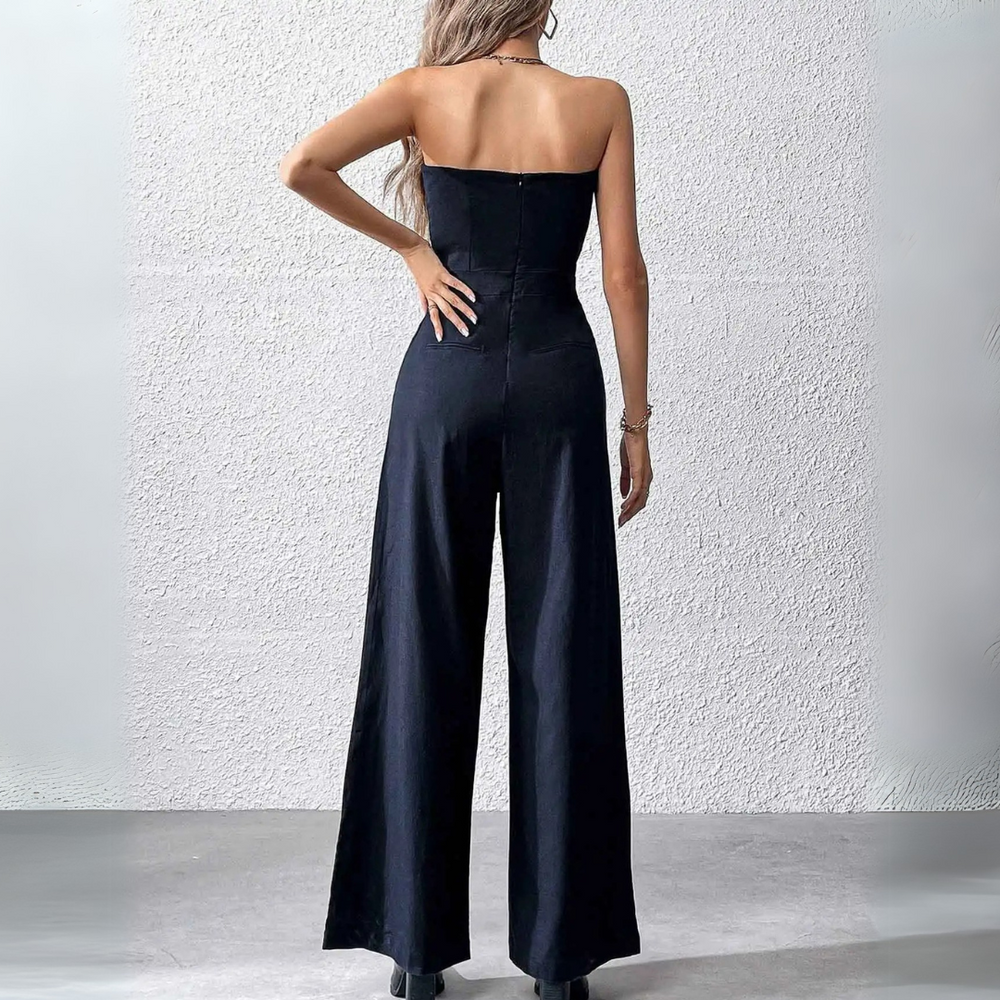 Frau in schwarzem, schulterfreiem Jumpsuit, Rückansicht. Elegante Mode, Abendgarderobe, stilvoll, modern, minimalistisch.