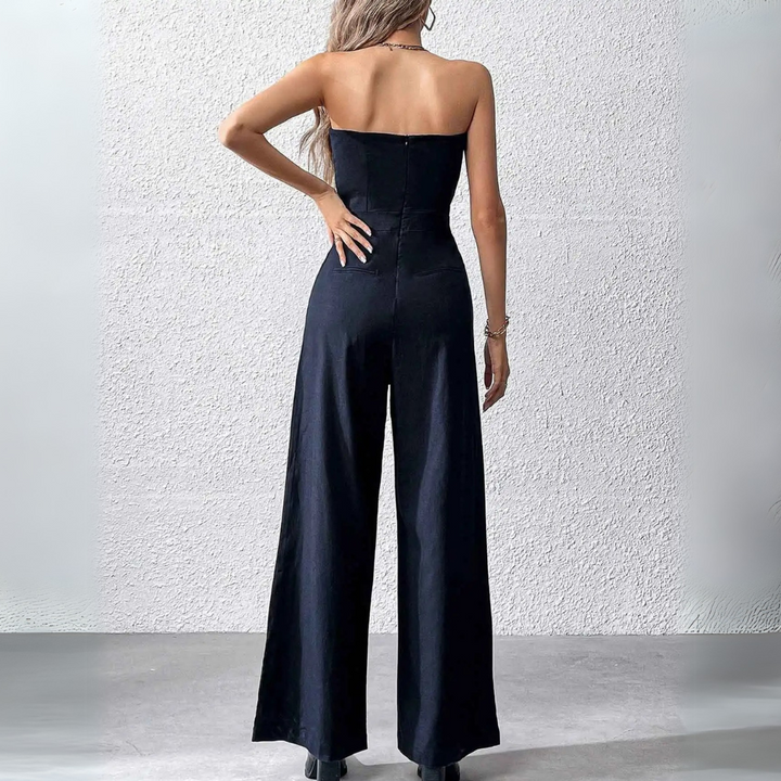 Frau in schwarzem, schulterfreiem Jumpsuit, Rückansicht. Elegante Mode, Abendgarderobe, stilvoll, modern, minimalistisch.