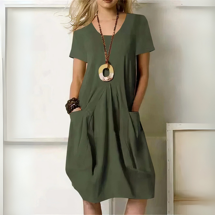 Frau in olivgrünem Sommerkleid mit Taschen, Holzschmuck und lockigem Haar. Modetrend, lässiger Stil, Damenmode, Sommeroutfit.