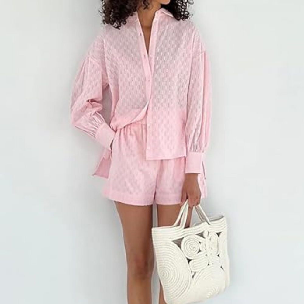 Frau in rosa Sommeroutfit mit Hemd und Shorts, hält weiße, geflochtene Tasche. Modetrend, Damenmode, lässiger Stil, Sommerkleidung.