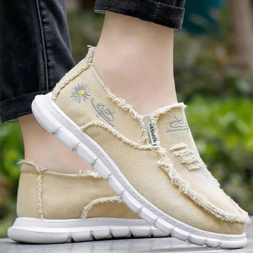 Beige Damen-Sneaker mit Blumenstickerei, Fransen-Design und weißer Sohle. Modische Freizeitschuhe für Frühling und Sommer.