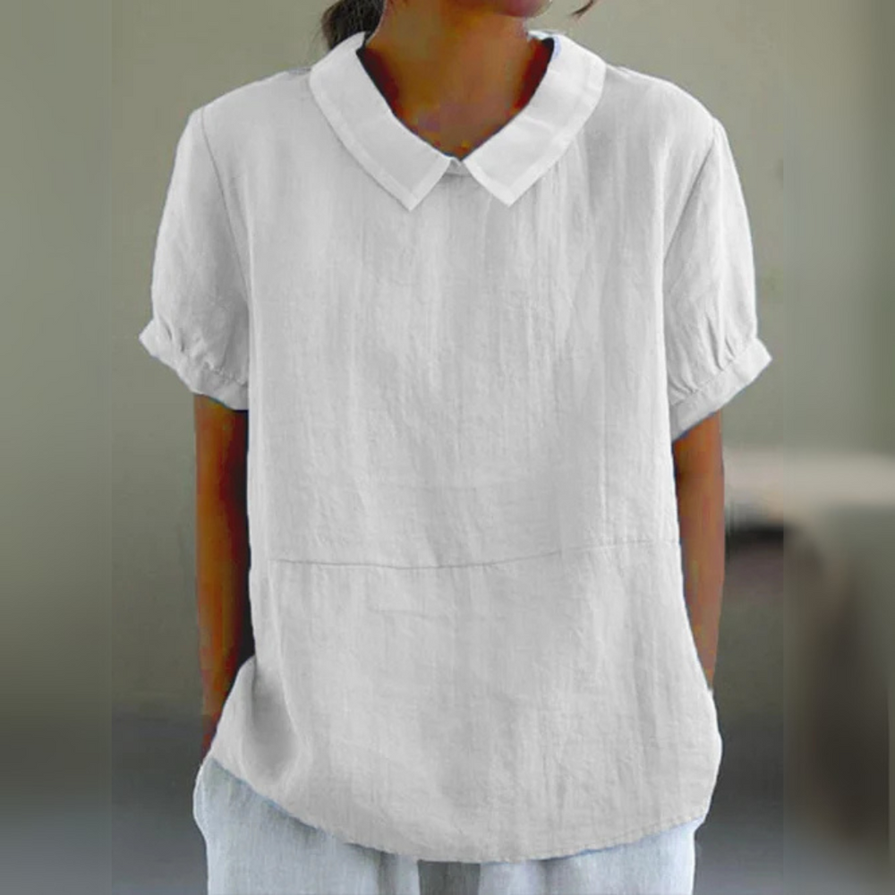 Frau trägt weiße Leinenbluse mit Kragen und kurzen Ärmeln. Modetrend, Sommerkleidung, Damenoberteil, lässiger Stil.