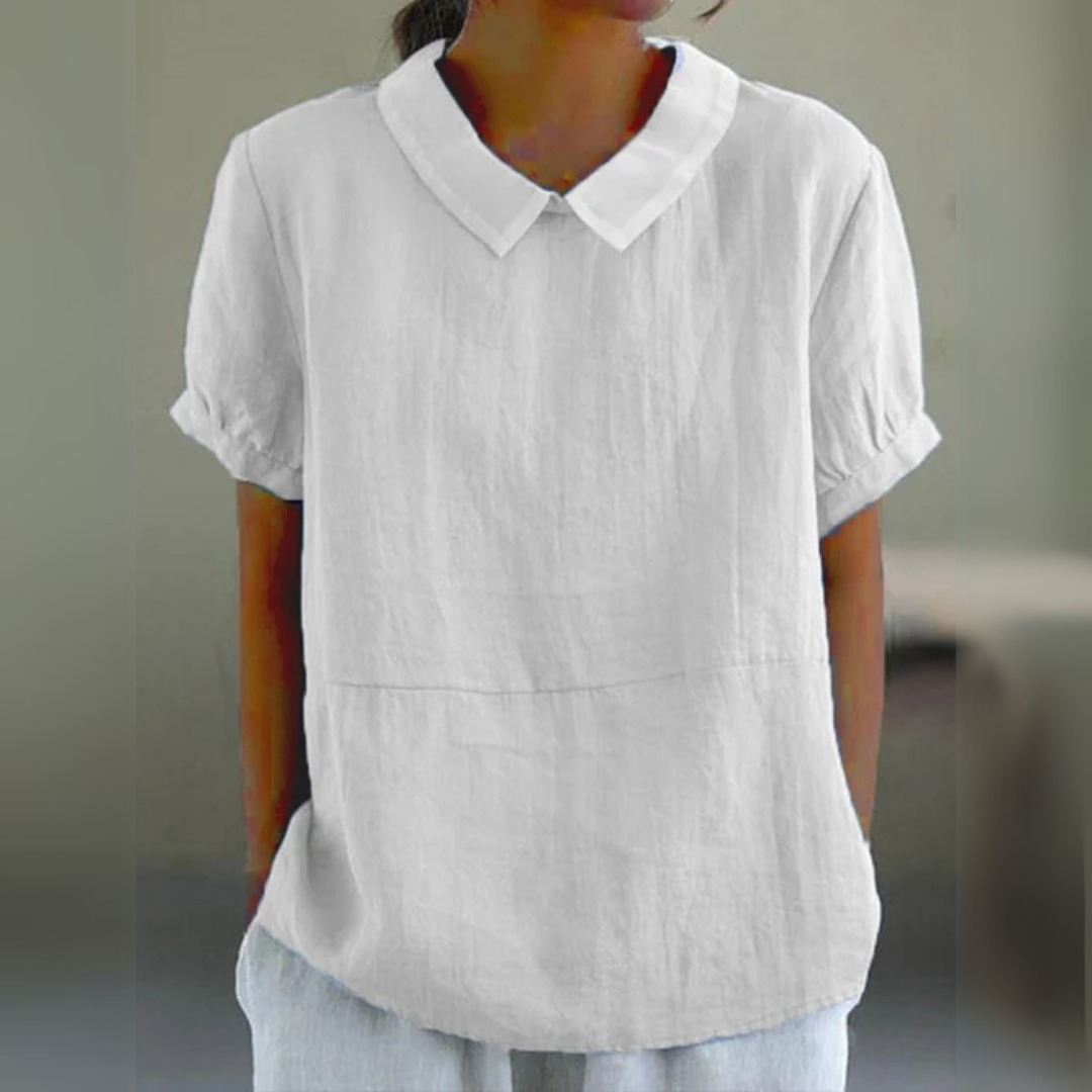 Frau trägt weiße Leinenbluse mit Kragen und kurzen Ärmeln. Modetrend, Sommerkleidung, Damenoberteil, lässiger Stil.