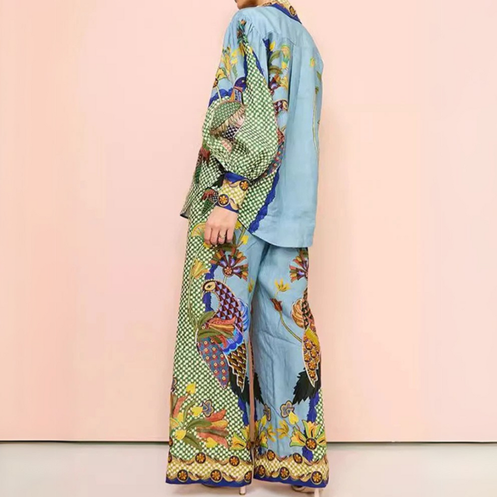 Frau in bunter, gemusterter Pyjama-Set mit Vogel- und Blumenmotiven vor rosa Hintergrund, modisch, bequem, Nachtwäsche, Damenmode.