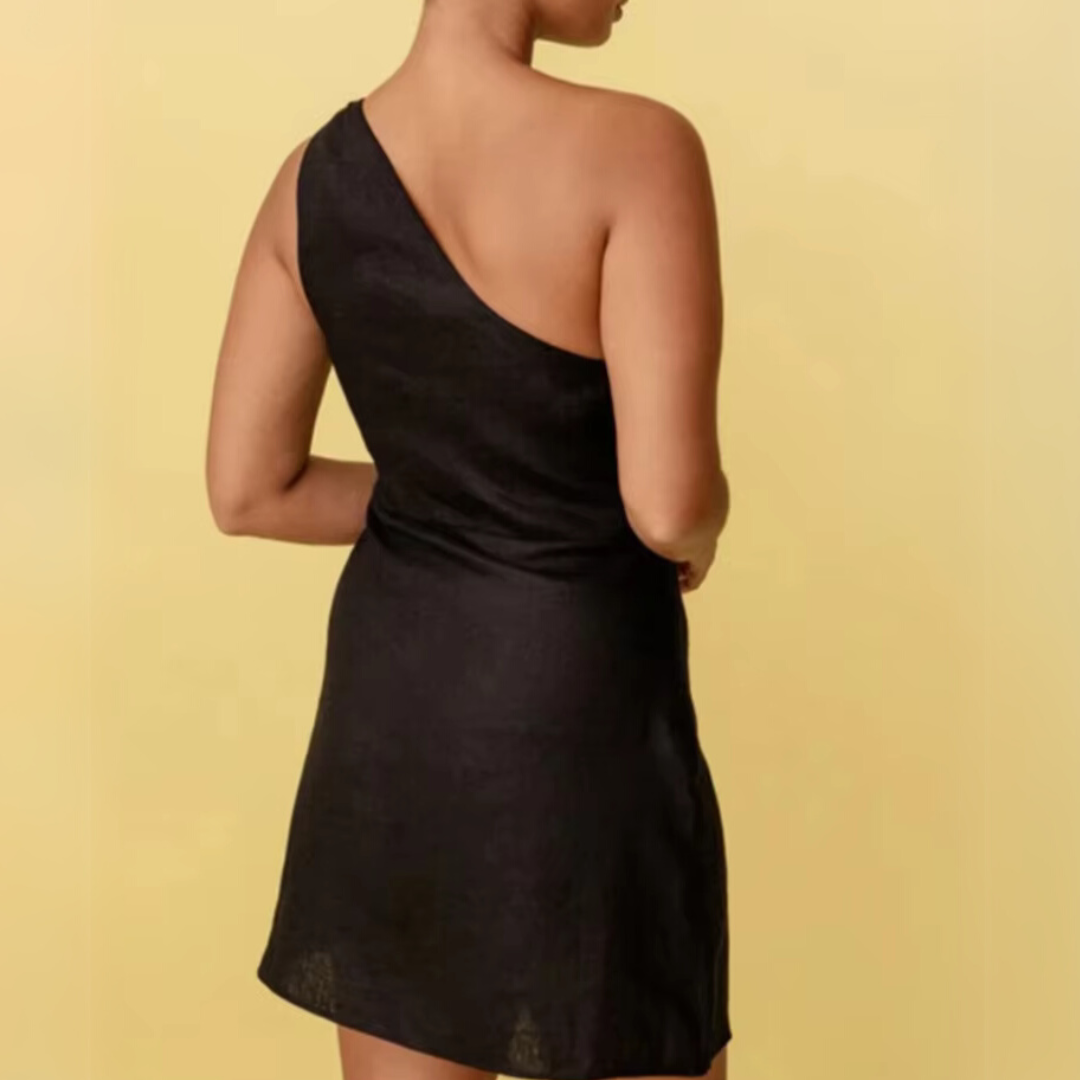 Frau in schwarzem, schulterfreiem Kleid vor gelbem Hintergrund. Elegantes, asymmetrisches Design, ideal für Abendmode und Partys.