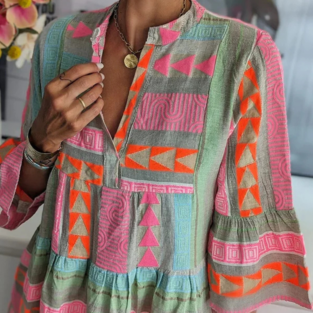 Bunte Boho-Bluse mit geometrischen Mustern in Pink, Orange und Grün. Ethno-Stil, lockerer Schnitt, ideal für Sommermode und Festival-Looks.